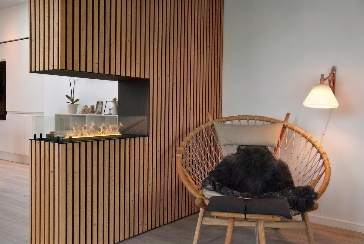 Foco Myst Room Divider 800 water vapour fireplace in a Scandinavian living room with a wood-slat surround, with a low lit water vapour flame